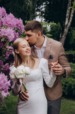 Güzel, mutlu, genç bir çift parkta birbirlerine sarılıyorlar..              