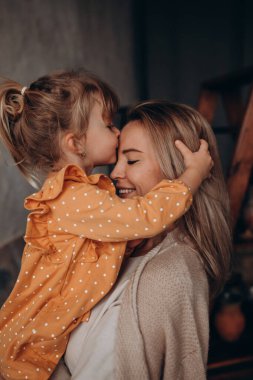 Mutlu anne-kız stüdyoda, kızı burada öpüşüyor. 