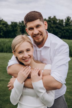 Güzel, mutlu, genç bir çift parkta birbirlerine sarılıyorlar..              