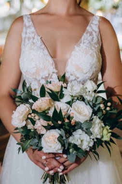 Güzel bir düğün buketi tutan genç gelinin yakın çekimi.        