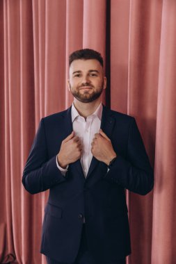 Genç ve yakışıklı bir damat stüdyoda poz veriyor.