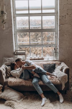 Genç çift stüdyoda kanepede yatıyor.