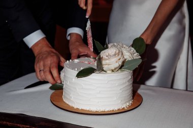 Gelin ve damat restoranda düğün pastası kesiyorlar..