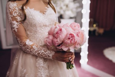 Güzel bir düğün buketi tutan genç gelinin yakın çekimi.        