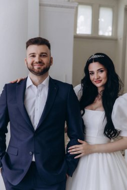 Mutlu gelin ve damat kameraya gülümsüyor. 