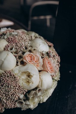 Lüks alyansların ve güzel narin çiçeklerin yakın çekimi.       