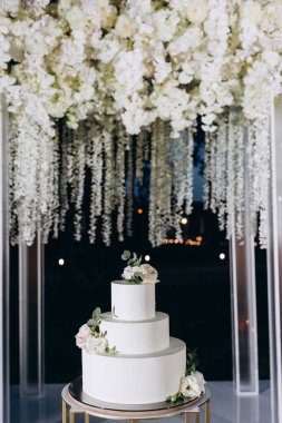 Nefis düğün pastası ve çiçeklerle süslenmiş güzel bir dekor.                 