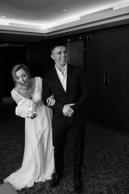 Mutlu genç bir çift otelde gülüyor, siyah ve beyaz.