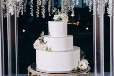 Nefis düğün pastası ve çiçeklerle süslenmiş güzel bir dekor.                 