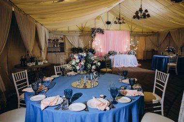 Düğün resepsiyonu için çiçekli ve mumlu masa, akşam yemeği organizasyonu..        