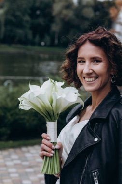 Güzel mutlu genç gelinin portresi düğün buketi tutuyor.    