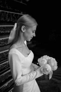 Güzel mutlu genç gelinin portresi düğün buketi tutuyor.    