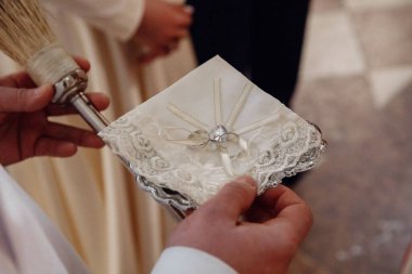 Düğün töreninde elinde yüzüklerle rahibin yakın çekim görüntüsü.