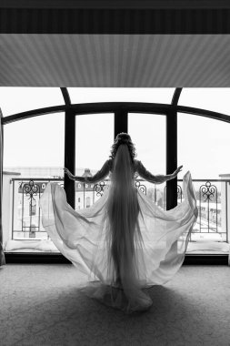 Beyaz gelinlik ve duvak giymiş güzel gelinin arkadan görünüşü