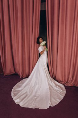 Stüdyoda poz veren zarif gelinlik içindeki genç ve güzel gelin.        