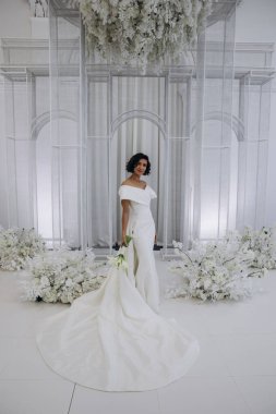 Stüdyoda poz veren zarif gelinlik içinde güzel genç bir gelin.          