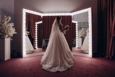 Stüdyoda poz veren zarif gelinlik içindeki genç ve güzel gelin.        