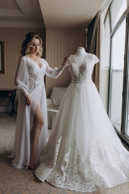 # Güzel genç gelin, beyaz gelinlikle poz veriyor evde sabah # 