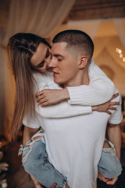 Genç ve güzel bir çift odada birbirine sarılıyor.