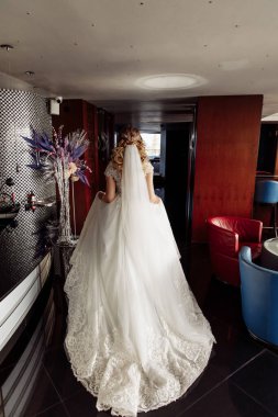 Gelinlik içinde lüks içinde yürüyen güzel gelinin arka manzarası.