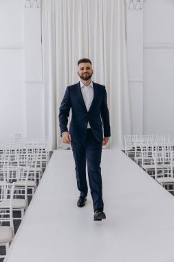 Stüdyoda poz veren şık takım elbiseli yakışıklı damadın portresi.       