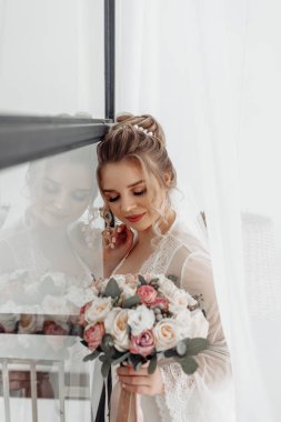 Güzel mutlu genç gelinin portresi düğün buketi tutuyor.    