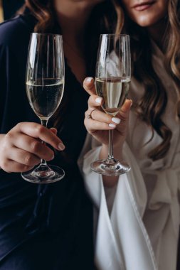 Şampanya bardakları tutan iki güzel genç kadın.