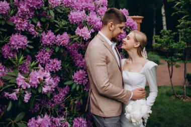 Genç ve mutlu bir çift bahar parkında poz veriyor.