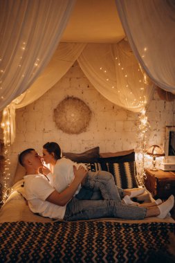 Bir çift genç aşık yatak odasında uzanıp öpüşüyorlar.. 