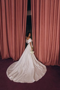 Stüdyoda poz veren zarif gelinlik içinde güzel genç bir gelin.          