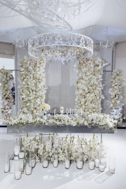 Güzel beyaz çiçekler ve mumlarla süslenmiş düğün süsleri.