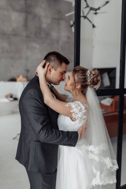 Mutlu gelin ve damat kucaklaşıyorlar ve birbirlerine bakıyorlar.