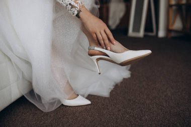 Beyaz gelinlik ve ayakkabı giymiş genç gelinin yakın plan görüntüsü. 