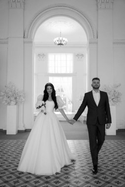 Törende el ele tutuşan güzel bir çift, siyah ve beyaz.