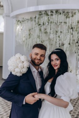 Düğün salonunda poz veren mutlu gelin ve damat