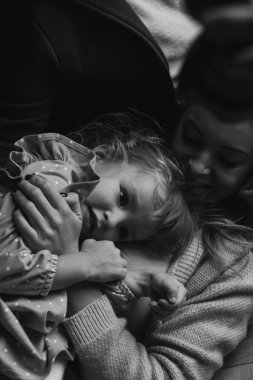 Güzel bir kızı olan genç bir anne evdeki yatak odasında yatıyordu. siyah beyaz fotoğraf 