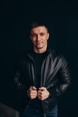 Siyah deri ceketli yakışıklı bir adamın portresi.