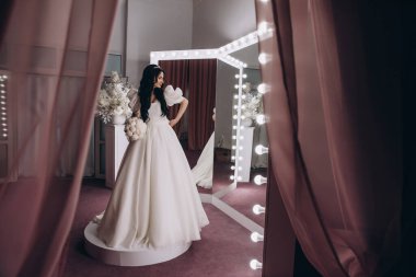 Stüdyoda poz veren zarif gelinlik içinde güzel genç bir gelin.          