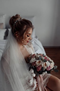 Duvak takmış, elinde düğün buketi tutan muhteşem genç gelinin portresi