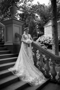 Parktaki merdivenlerde bekleyen güzel gelin. siyah ve beyaz