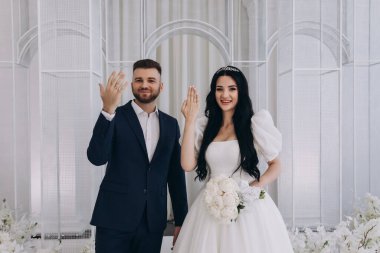 Gelin ve damat törende alyanslarla el ele tutuşuyorlar.