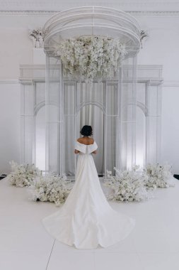 Beyaz elbiseli gelinin iç mekânda poz verişi.