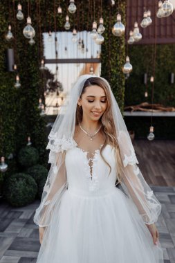 Çekici, mutlu, beyaz gelinlik ve peçeli gelin.