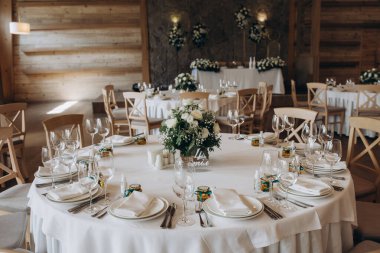 Mumlar, çiçekler ve bardaklarla düğün masası. 