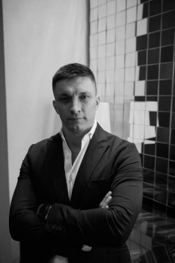 İçerde poz veren zarif kıyafetli yakışıklı damadın portresi.        