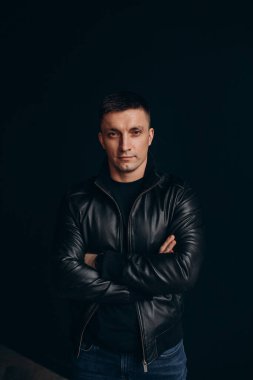 Siyah arka planda deri ceketli yakışıklı bir adam..