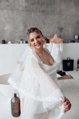 Gelinlikli mutlu gelin banyoda poz veriyor.