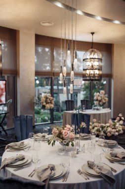 Düğün için çiçeklerle süslenmiş zarif bir masa seti ya da yemek servisi.                