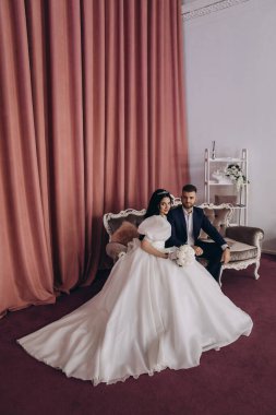 Güzel bir çift birlikte oturuyor ve stüdyoda poz veriyorlar.