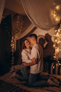 Mutlu, genç bir çift, sıcak bir yatakta sarılıyorlar.